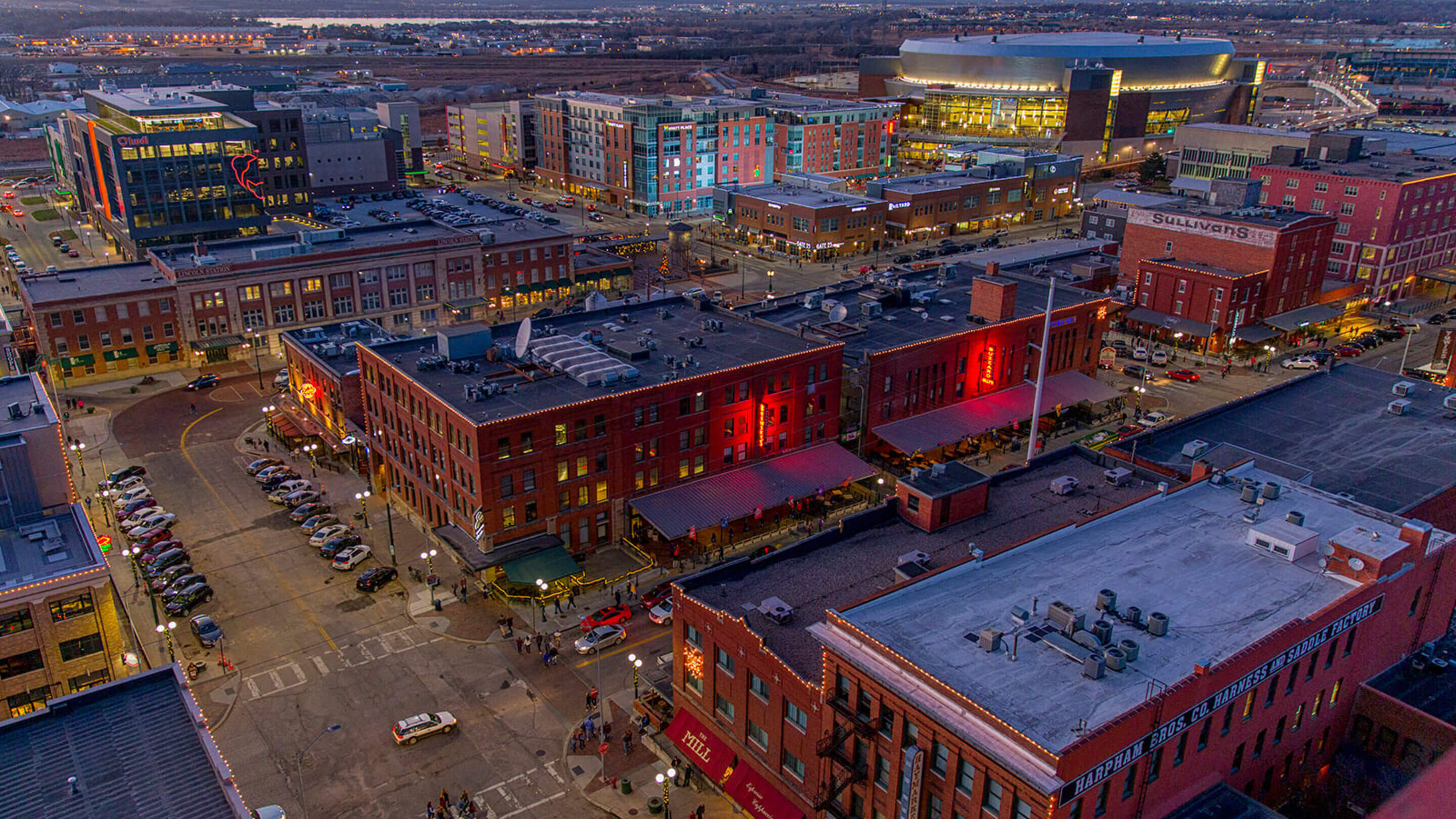 Buildings lit up at night in the Haymarket downtown Lincoln facing campus