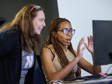 Student and faculty member looking at computer screen